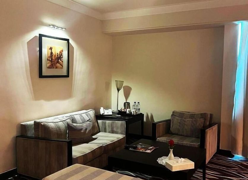 Grand Lancaster Brazzaville lounge seating area with sofa, armchair, ottoman and coffee table