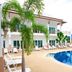 Nadivana Serviced Apartment in Krabi with a palm-lined pool and sun loungers outside the building