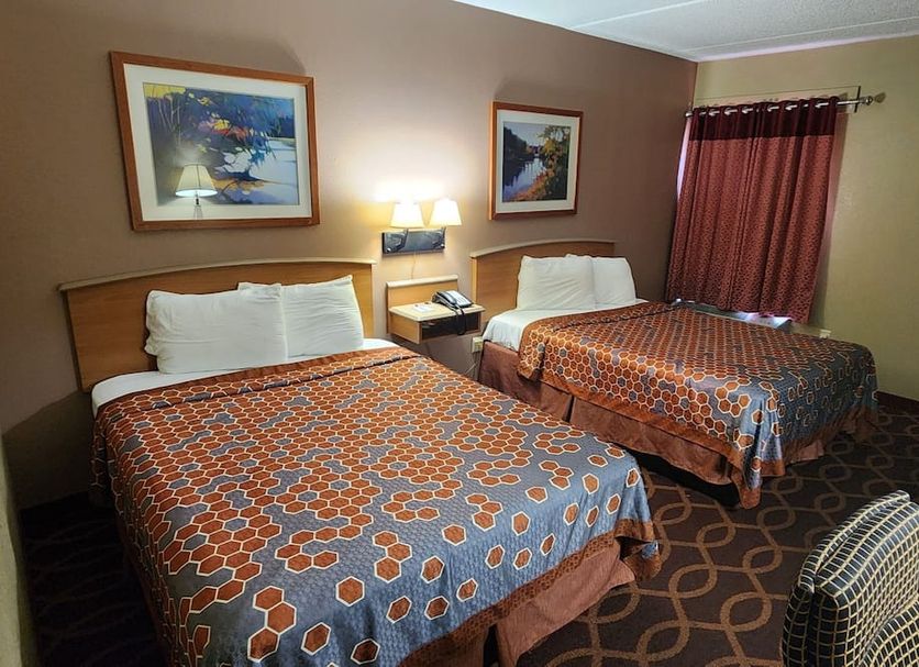 American Inn Evansville East room with two beds, bedside lamp, framed art and curtain in Evansville