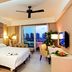 Guesthouse International Hotel Sanya room with king bed, desk, city view balcony, and ceiling fan