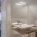 Hôtel Spa - Au Charme Rabelaisien in Amboise bathroom with vessel sink and mirror, leading to a cozy room