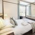 Hawksmoor Guest House in Windermere bedroom with four-poster bed, sofa, and wall-mounted TV