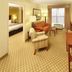 Country Inn & Suites by Radisson, Crystal Lake, IL suite with sitting area, dining table and TV