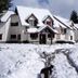 Posada del Angel in San Carlos de Bariloche, snow-covered chalet-style hotel exterior with pine trees