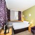 Kents Hill Park Training & Conference Centre room in Milton Keynes with double bed, desk and purple armchair