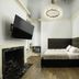 The Edward Buffalo in Buffalo guest room with fireplace, wall-mounted TV, and ornate bed