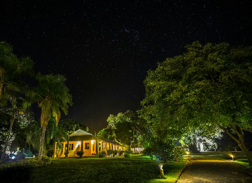 Puerto Valle Hotel De Esteros in Puerto Valle at night, lit lodge surrounded by lush tropical trees