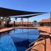 Hospitality Port Hedland pool terrace with shade sails and palm-lined resort buildings in Port Hedland