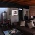 Hotel del Vasco in Zacatecas: rustic room with brick accent wall, dark sofa, bed, and kitchenette