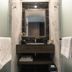 Spice House in Chiang Mai bathroom vanity with mirror, sink, towels, and frosted glass shower doors