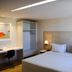 America Bittar Hotel Brasília room with double bed, desk, wardrobe and bedside lamp
