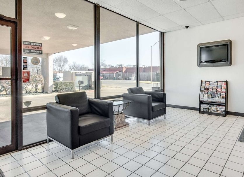 Motel 6 Longview, Tx - North lobby seating area with chairs, TV, and large front windows