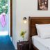 Sun City Hotel in Tel Aviv guest room with single bed, bedside table, wall light, and balcony view