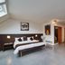 Threeland Hotel Pétange guest room with bed, sofa seating area, and skylight
