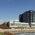 Delta Hotels by Marriott Thunder Bay exterior by the waterfront with a reflective pond and blue sky