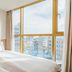 Kenny Stay Jeju Seoguipo room with twin beds and city views through large windows in Seogwipo