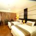 Ros-In Hotel Yogyakarta guest room with two beds, desk, and warm lighting in Yogyakarta