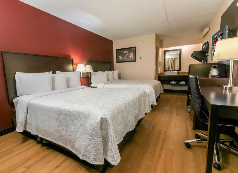 Red Roof PLUS+ Nashville South - Fairgrounds guest room with two beds, desk and wood flooring in Nashville