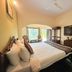 Raj Palace Resort in Sawāi Mādhopur guest room with king bed, wall TV, and balcony seating