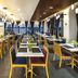 ibis Saigon South restaurant dining area with tables, blue chairs and large windows in Ho Chi Minh City