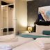 Hotel Mika Downtown in Budapest guest room with king bed, abstract wall art, and en suite shower