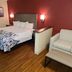 Red Roof Inn & Suites Cornelius - Lake Norman guest room with bed, sofa, desk and wood flooring in Cornelius
