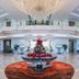 Haiqing Hotel Qingdao grand lobby with chandelier, twin staircases, glass railings, and floral centerpiece