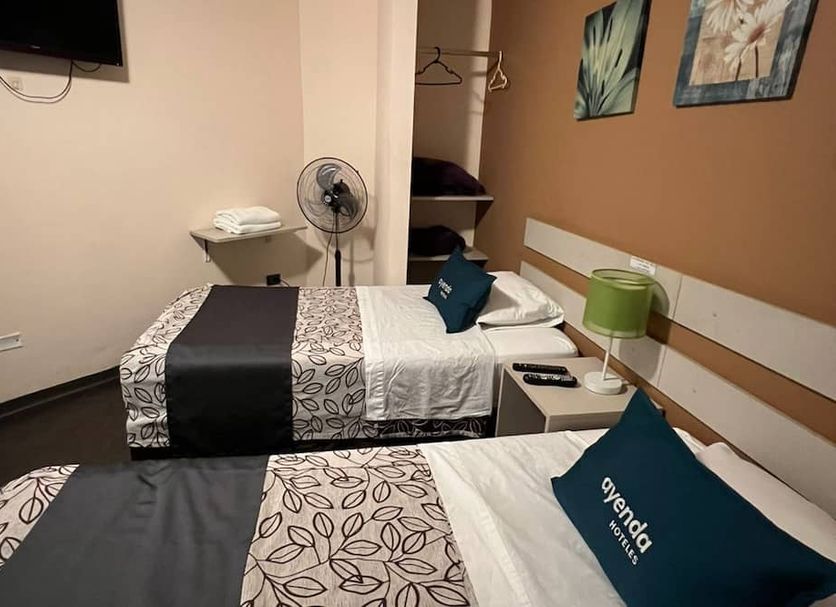 B&B Wasi Airport Lima room with two twin beds, wall TV, fan and bedside lamps in Lima