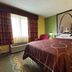 Super 8 by Wyndham Jacksonville guest room with king bed, green walls, and Gateway Arch wall art