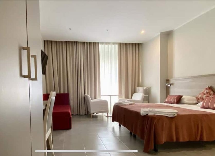 Hotel Vintage Milano Centrale room in Milan with bed, armchair and window with curtains