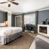Big Bear Spa Suites in Big Bear Lake: bedroom with king bed, desk, fireplace, and window with curtains