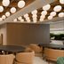 Hilton Garden Inn Mexico City Polanco lounge with round tables, tan chairs and hanging globe lights