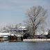 Mingcheng Hotel Beijing by the water with snow-covered trees and traditional Chinese-style buildings