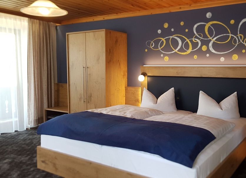 Hotel-Gasthof Zum Oberen Wirt, Regen: cozy guest room with double bed, wood furnishings, and patterned wall art