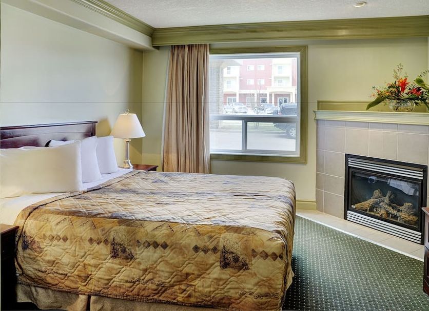 Nova Inn Edson guest room with king bed, fireplace, window view and armchair