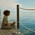 Nido, Mar-Bella Collection an SLH hotel in Agios Ioannis Peristeron, guest reading on a wooden seaside deck