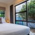 Tasman Holiday Parks - Coromandel room with bed and large windows overlooking trees and water