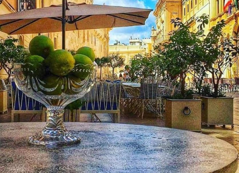 Rudy Arenaile in Arenella: outdoor courtyard with decorative glass bowl of green spheres and umbrellas