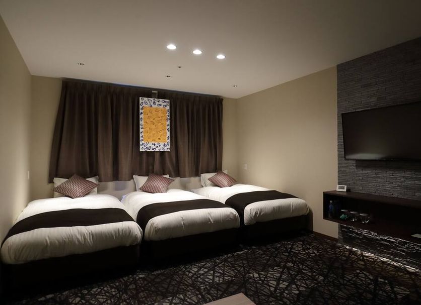 Osaka Teikoku Hotel in Osaka guest room with three twin beds and wall-mounted TV
