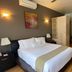 Hotel Villa Condesa room in Mexico City with king bed, sofa, colorful wall hanging, and wood floors