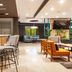 Courtyard by Marriott San Salvador lobby bar with stools, lounge seating and bright modern interior