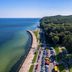 Rozany Gaj in Gdynia with seaside promenade, beach, parked cars and forested coastline
