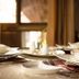 Zawadi House Arusha dining table set with white bowls, plates, and cutlery in a warm room