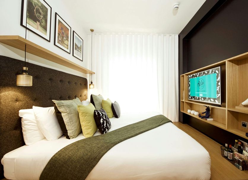 Wilde Aparthotels London Covent Garden guest room with bed, built-in shelving and window seat in London