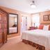 Brick Street Inn in Zionsville guest room with a bed, armoire, vanity, and two windows