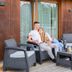 Guests relaxing on a patio at Hotel Bonvino Badacsony, with outdoor seating and a wooden facade