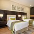 Wyndham Garden Manama twin room with desk, wood floor, and framed wall art in Manama