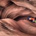 High Desert Inn, Salina: two people in helmets navigating a narrow red sandstone slot canyon