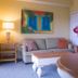 Barefoot Suites Kissimmee suite living room with sofa, lamp, coffee table and colorful wall art