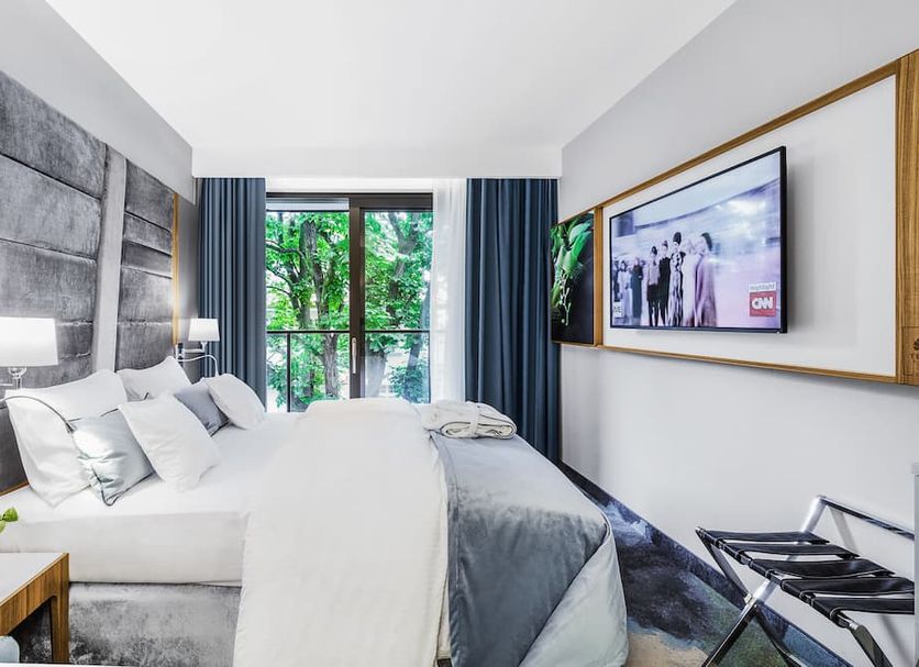 Hotel Testa Sopot guest room with king bed, balcony doors, and wall-mounted TV